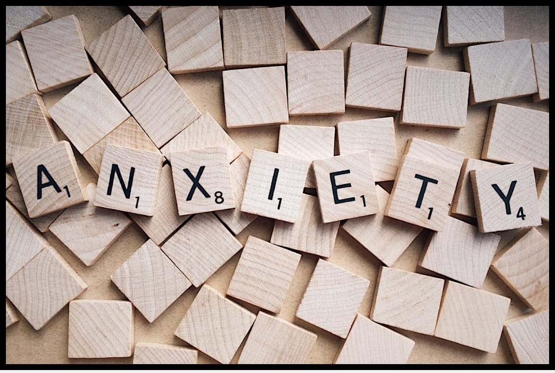 scrabble tiles with the word anxiety spelled out